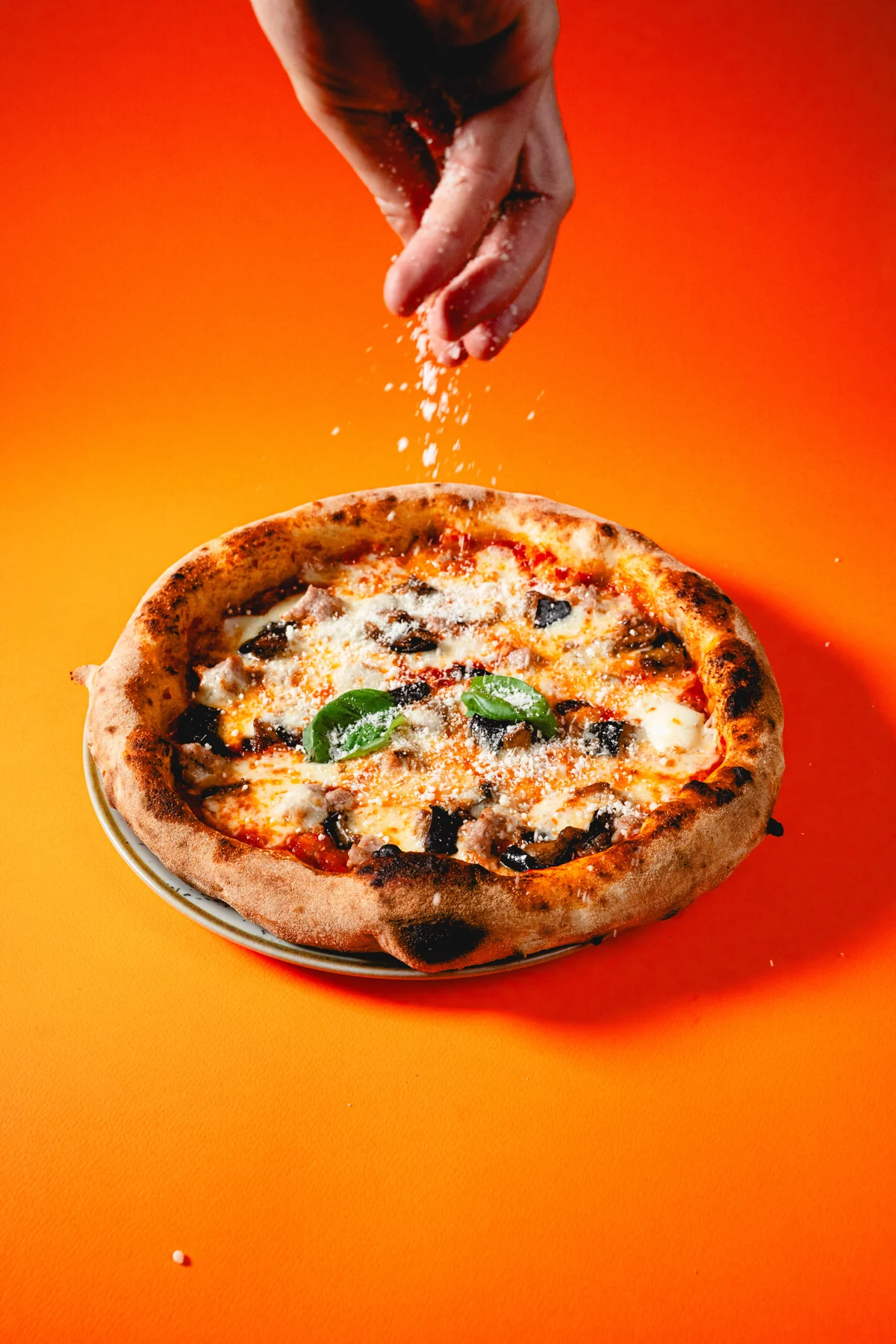Il gesto finale del pizzaiolo sulla pizza