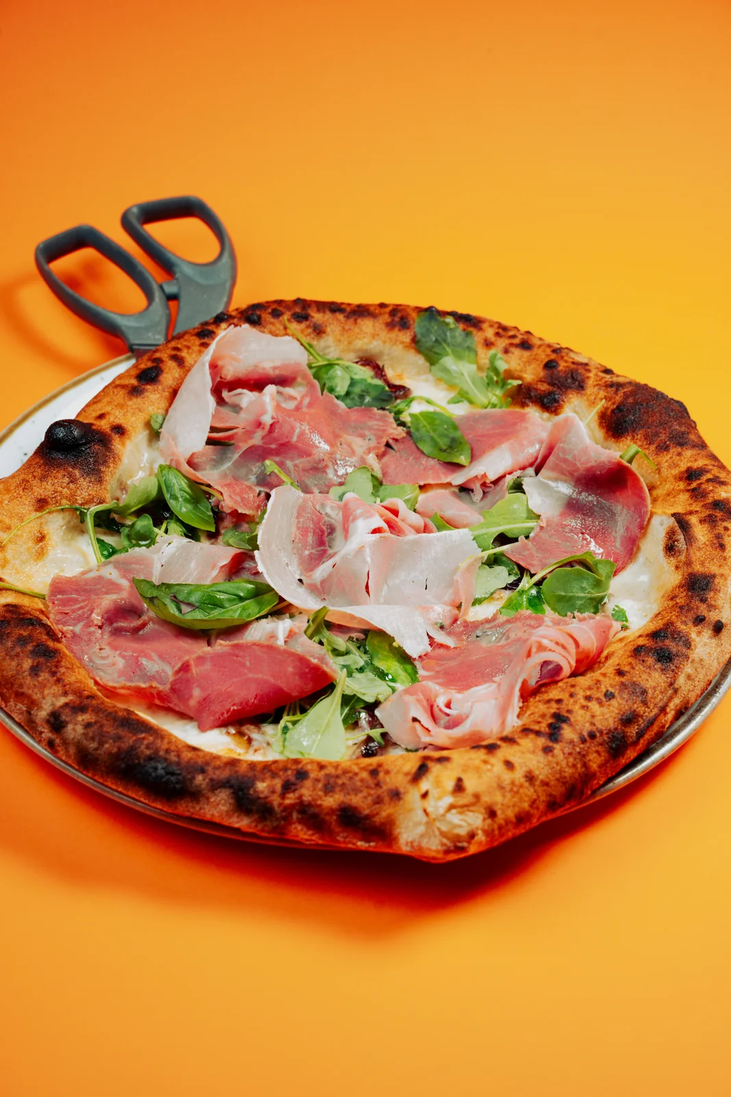 Pizza con salumi e basilico fresco